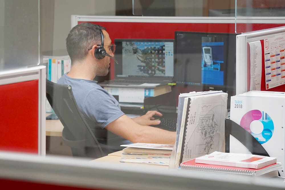 Homme avec casque de communication devant son écran